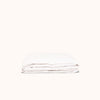 A folded white fitted matte sateen sheet on a white background.